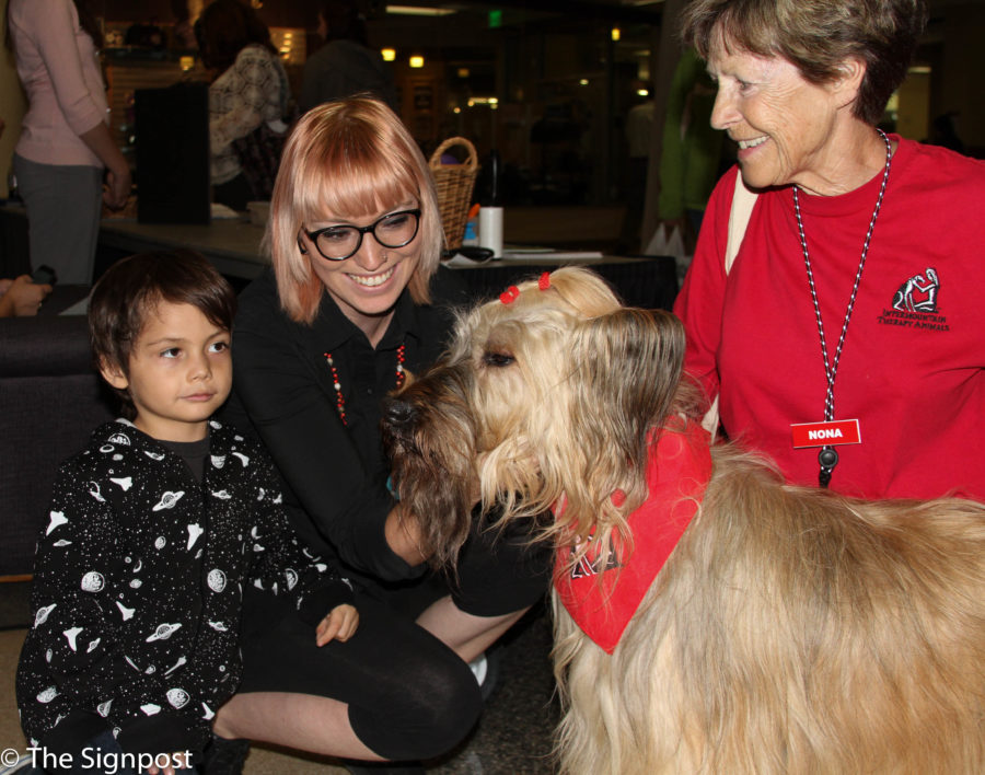 Brody Peterson, 5, and his mother Kylie enjoy the company of Tosca, a Briard, and her owner Nona Horsley.