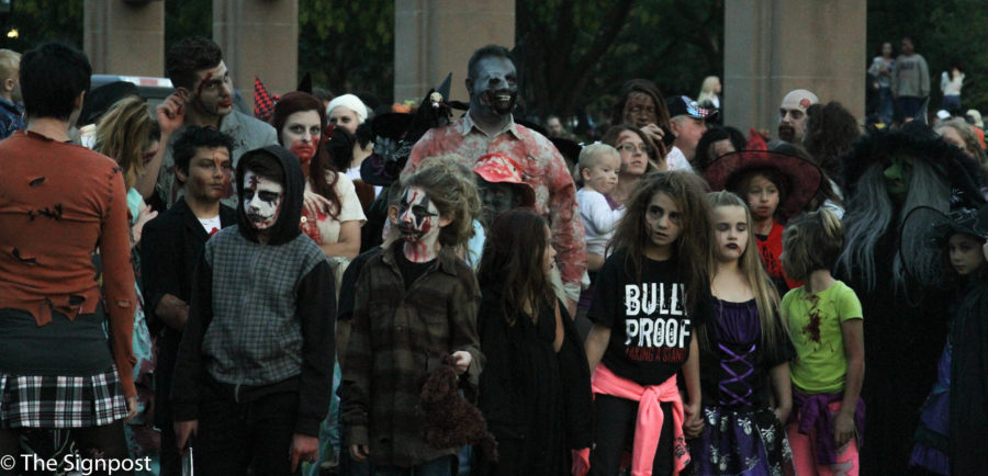 Zombies wait at the starting line as onlookers watch at the Zombie Crawl on 25th St. on Saturday.