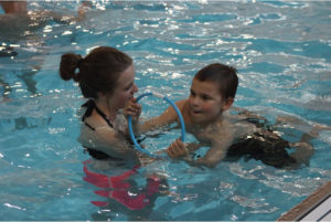 Weber State University Student Madison works with CAPES! participant Casen on focusing and following directions in the pool. (Source: James Zagrodnik)
