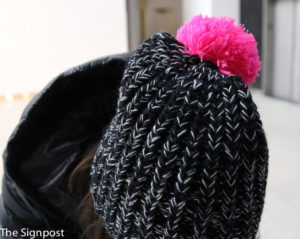 Lara McAllister adds a black, grey and pink beanie to her outfit. (Gabe Cerritos / The Signpost)
