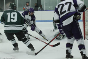Forward Zan Hobbs attempts to get the puck in the goal. (Abby Van Ess / The Signpost)