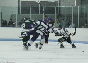 A Michigan State player pushes Forward Dax Hobbs in an attempt to get the puck. (Abby Van Ess / The Signpost)