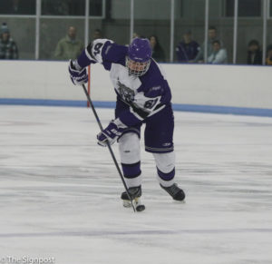 Senior Cody Bohin drives the puck down the ice during the game. (Ariana Berkemeier / The Signpost)