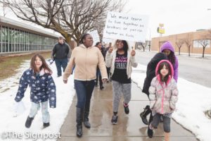 Akeara Belt, 10 carries a sign with a MLK quote during the annual Martin Luther King Jr. celebration march . (Christina Huerta / The Signpost)