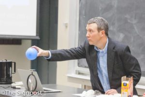 Dr. Adam Johnston gives a demonstration on static electricity during his "Physics of the Mudane" seminar.(The Signpost/ Christina Huerta)