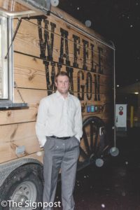 Greg Timothy, owner of the Waffle Wagon, stands next to one his food trucks after speaking at the Subaru Entrepreneurship Lecture Series. (Christina Huerta/The Signpost)
