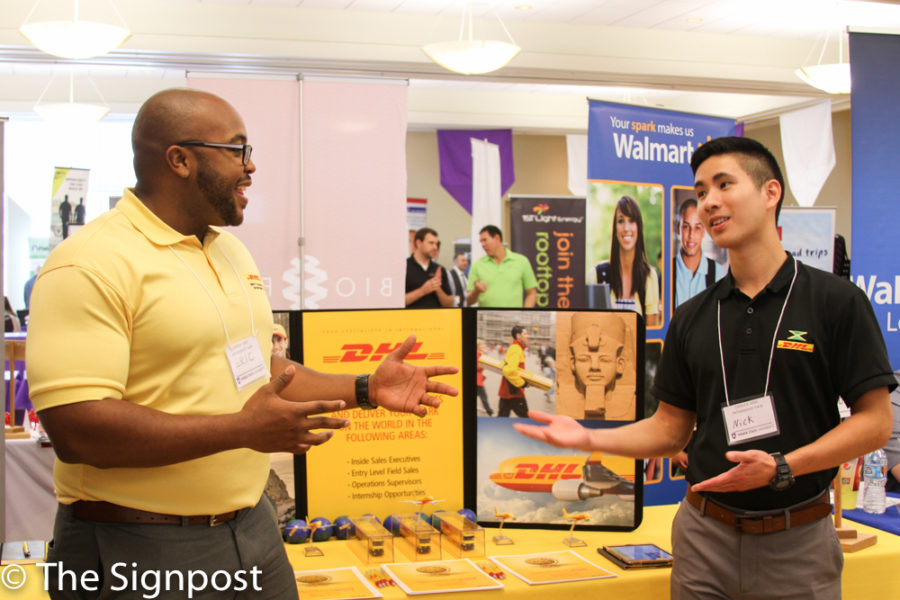 Eric Williams y Nick Chan de DHL Express hablan sobre los beneficios de su empresa en la feria de trabajo en WSU Career Fair del martes. (Abby Van Ess / The Signpost)