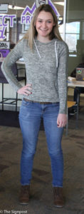 Sami McCain, a Freshman studying English with an emphasis in creative writing, wearing a grey and green lace sweater with blue jeans and brown boots. (Ariana Berkemeier / The Signpost)