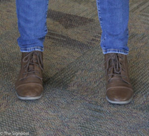 Sami McCain ties her outfit together wearing brown boots to match her brown belt. (Ariana Berkemeier / The Signpost)