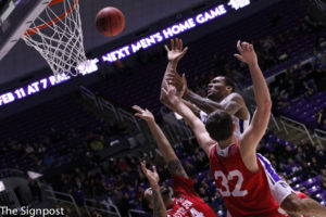 Senior Joel Bolomboy reaches over two SUU players to make a basket during the game. (Ariana Berkemeier / The Signpost)