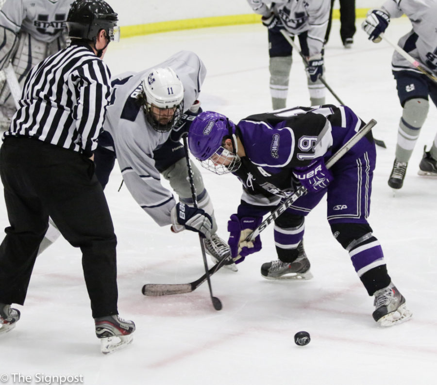 Left Wing Alex Pizarro attempts to win a face-off during the game against USU.  (Ariana Berkemeier / The Signpost)