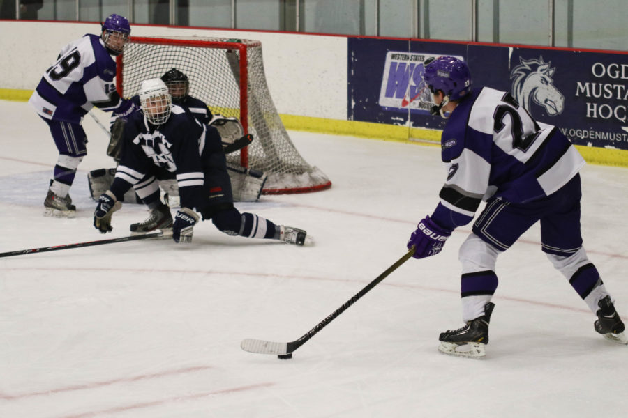Forward Dax Hobbs passes the puck to Alex Pizarro in attempt to score a goal.  (Ariana Berkemeier / The Signpost)