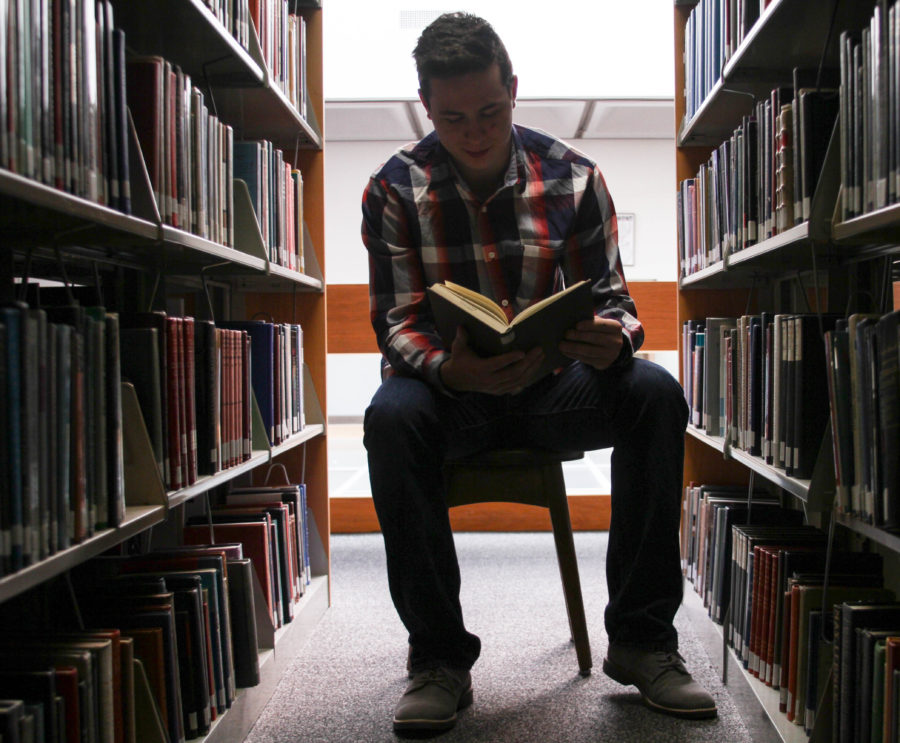 Freshman Carter Campbell finds himself lost in a book at the library. (Abby Van Ess / The Signpost)