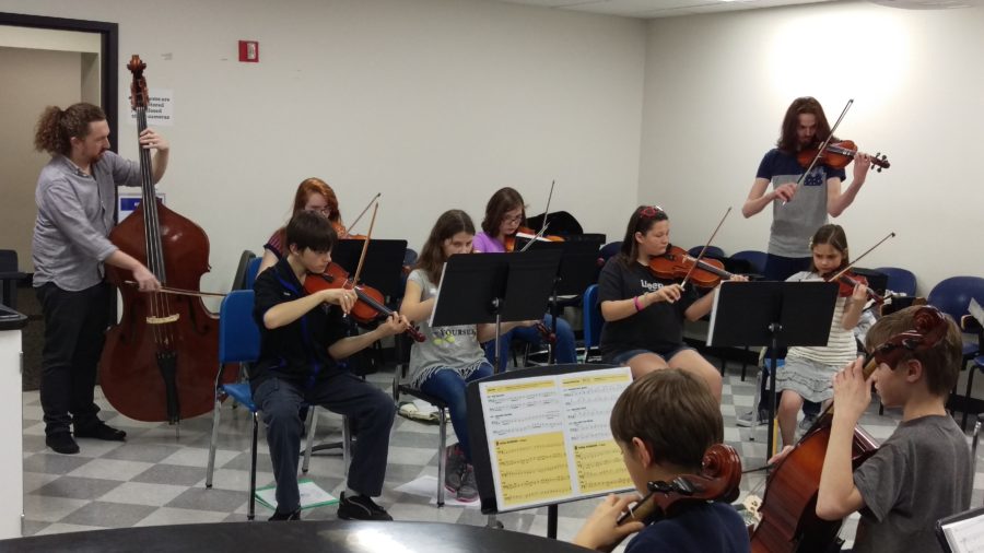 Spencer Howe teaches string students as an ensemble.