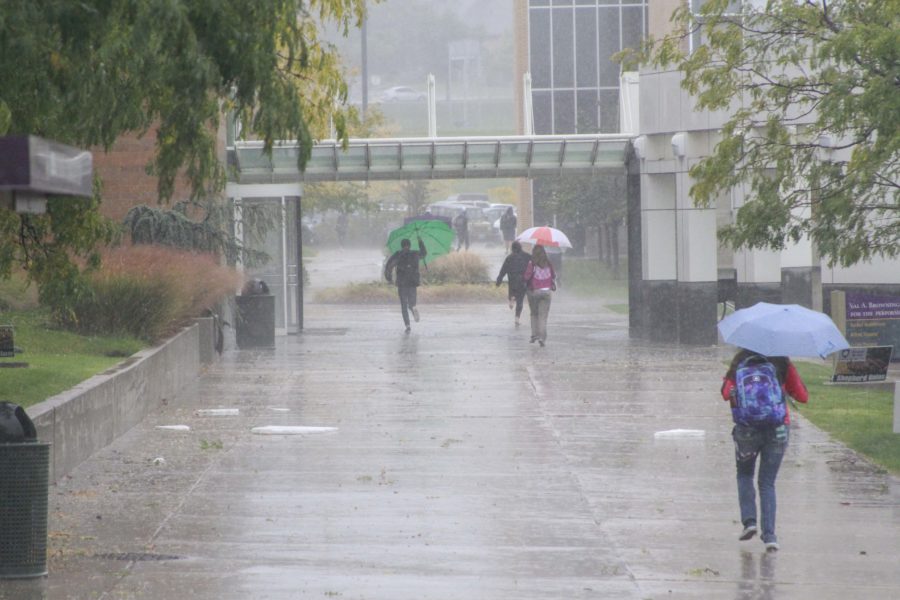 estudiantes de Weber State University afuera de Shepherd Union en la lluvia durante del tornado el 22 de septiembre. (Emily Crooks / The Signpost)