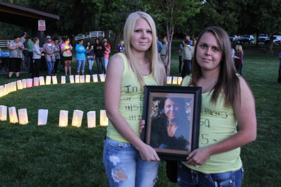 Young women hold a photograph of a loved one lost at a suicide prevention candlelight vigil in 2015. (The Signpost Archives)