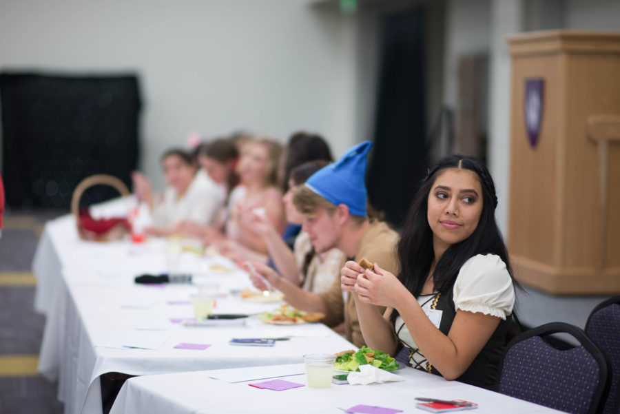 Gretel, played by Angelica Solis, sits with other members of the cast during the dinner portion of Murder Mystery, a time when a significant portion of the nights mystery is related to the audience. (Joshua Wineholt / The Signpost)