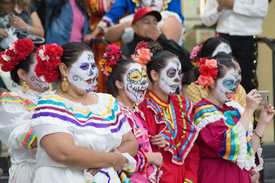 Mujeres con caras pintadas y vestidas en estilo típico para una celebración del Día del los Muerto bailan durante una noche de celebración en el edificio de Shepherd Union. (Maddy Van Orman / The Signpost)