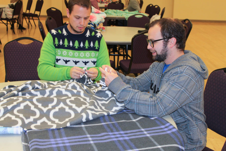 Students and faculty tie fabric into fleece blankets for children at McKay-Dee hospital on Nov. 23. (Rachel Storm / The Signpost)