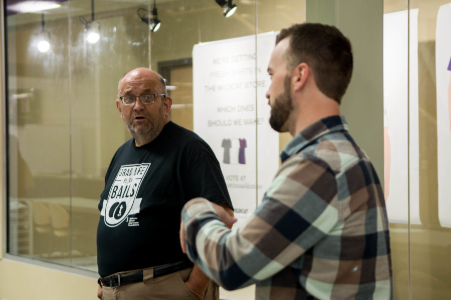 Russel Goodman, left, and Timothy Dunn, right, talk with guests about the dangers of testicular cancer and ways to give self-exams at the Testicular Cancer Awarenss Foundation booth on Novermber 4. (Joshua Wineholt / The Signpost)
