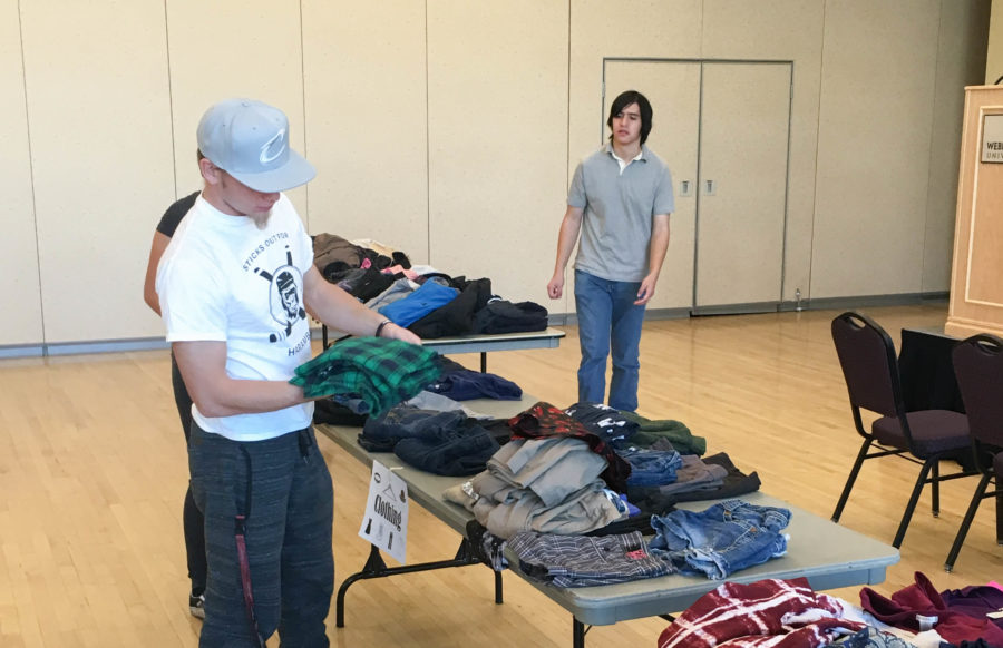 Students go through donated clothes at Weber State University at the Holiday Free Swap. Items that were left over will be donated to Savers, which will collect money for Weber Cares Food Pantry. (Ben Brandley / The Signpost)