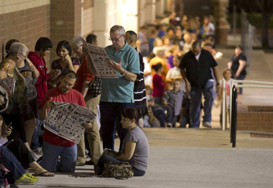 Left to right, Van Burruss, his father Van Burruss Sr., and his wife Amye Burruss study the Toys R Us advertisements as they wait in line with about 300 people for the store in Austin, Texas, to open at 8 p.m. for early Black Friday sales on Thursday, November 22, 2012.  (Jay Janner/Austin American Statesman/MCT)