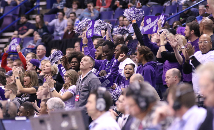 A crowd dressed in purple cheers on the mens basketball team in their first round of the NCAA Tournament in St. Louis, Missouri in Spring 2016. Student executives hold a meeting to discuss Weber Wear Friday and #JustWeber to boost overall school spirit. (The Signpost Archives)