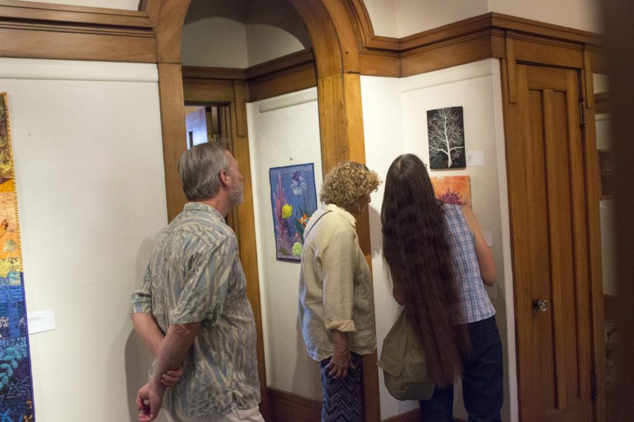 People observe the art at Eccles Community Art Center during an art stroll on Sept. 2. The center will exhibit exhibits the paintings of Charles R. Gilmore, Weber State painting alum, through Jan. 28. (The Signpost Archives)