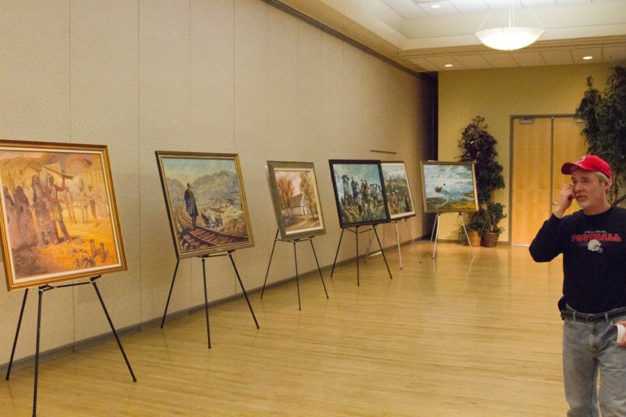 People observe historic paintings on Northern Utah displayed in Shepherd Union Ballroom on Feb. 14. (Dalton Flandro / The Signpost)