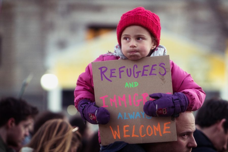 A young ralliers holds a sign, which reads refugees and immigrants always welcome, in protest to Trumps immigration ban in Washington D.C. in Jan. 2017. (Fuente: Lorie Shaull / flickr)