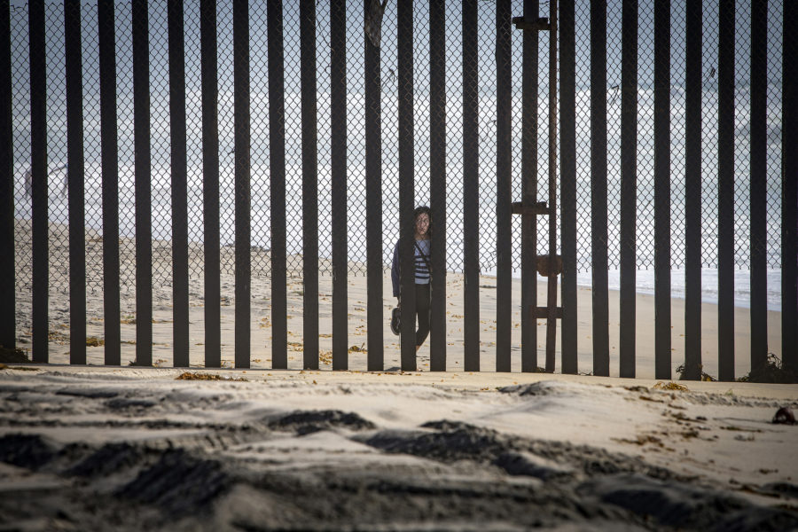 A person peers through the border fence from Tijuana, Mexico to Imperial Beah Calif. in April, 2016. Mexico has announced that they will not accept deportees from third countries. (Source: Tribune News Service)