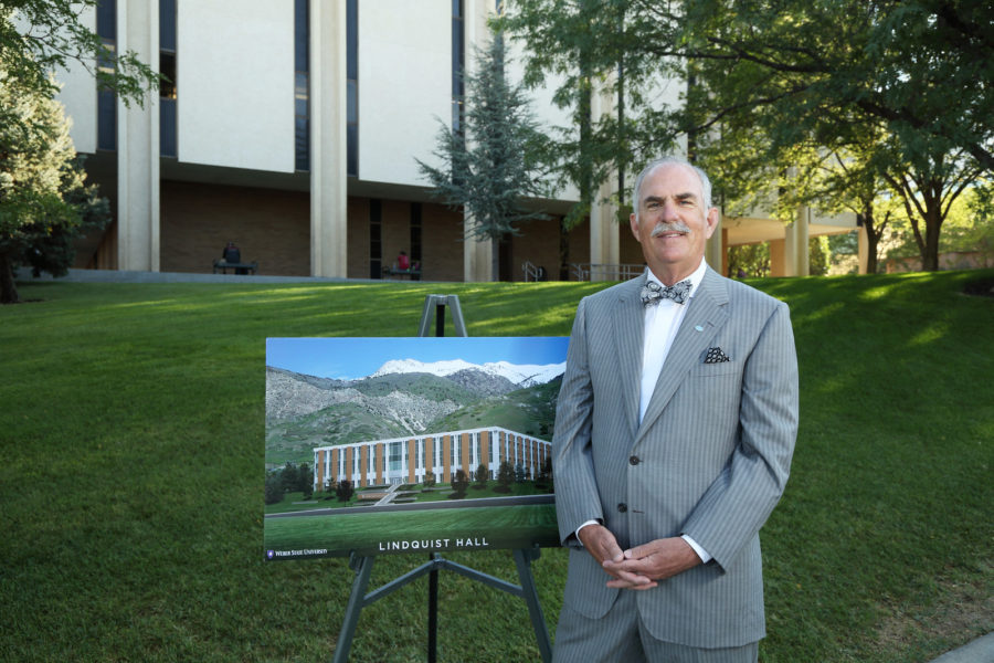John E. Lindquist stands next to a design plan for Lindquist Hall, a renovation of WSUs Social Science Building. Lindquist donated $5 million for the project. (Source: Weber State University)