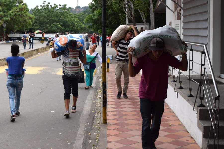 Venezuelans carry goods across the border in Cucuta, Colombia due to Venezuelas shortage of food. Venezuelas government will expropriate bakeries that do not supply enough bread. (Source: Tribune News Service)
