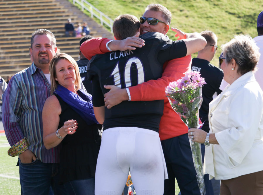Senior Jadrian Clark hugs his family members during an emotional Senior Day Nov 12. (Abby Van Ess / The Signpost)