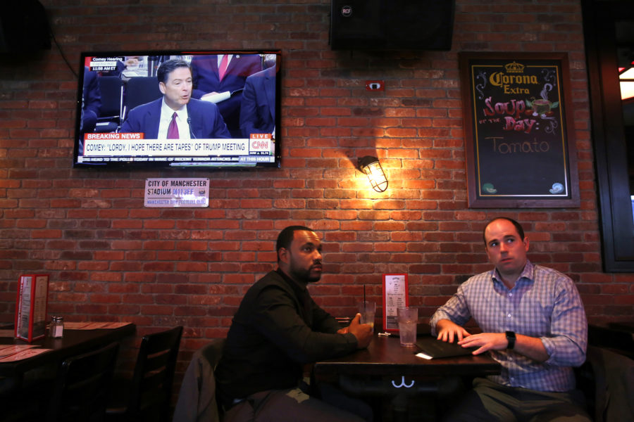 Former head of the FBI James Comey testifies regarding Russian intervention in the U.S. elections and other things on Thursday, June 8, 2017. At Tonic bar and restaurant near New Yorks Times Square, Chandler Green, left, of New Jersey, and Sam Henderson, of Norfolk, Va. listen at they finish having lunch. (Carolyn Cole/Los Angeles Times/TNS)