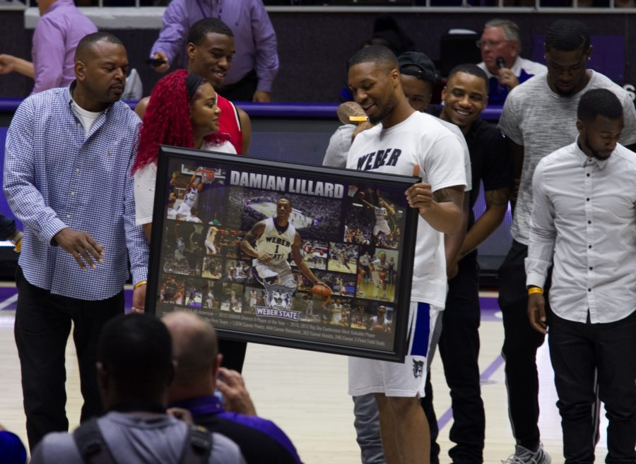 Surrounded by members of his family, Damian Lillard, center-right, accepts the poster signifying his athletic achievements as a Wildcat. (Joshua Wineholt / The Signpost)
