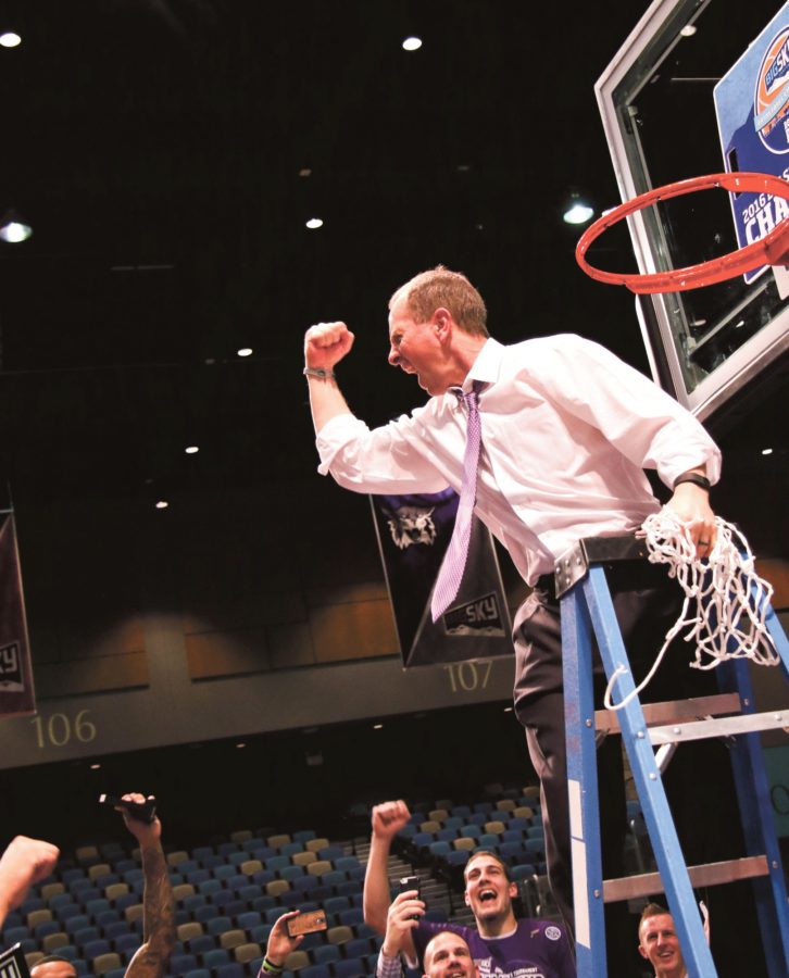 Head Coach Randy Rahe fists bumps to his team as he cuts down the net. (Signpost Archives)