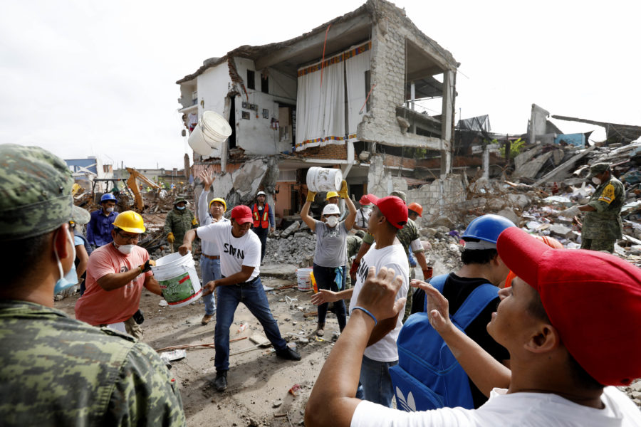 Volunteers along side the Mexican military remove rubble, beginning the reconstruction process where a block of homes were destroyed by the recent quake along calle 10 de Abril in Jojutla, Morelos, on September 23, 2017. (Gary Coronado/Los Angeles Times/TNS)