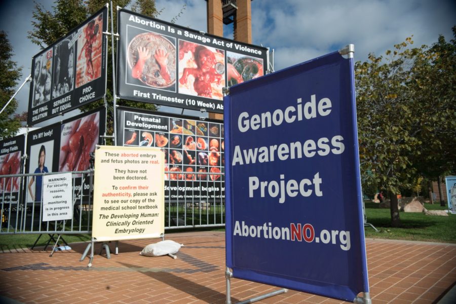 Pro-life signs and pictures line grass of Bell Tower Plaza. (Joshua Wineholt / The Signpost)