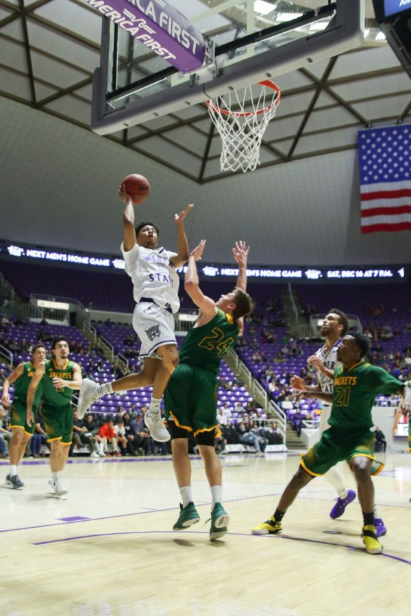 Ricky Nelson, goes in for a shot over Fraser Malcolm of Black Hills State. (Tony Post, The Signpost)