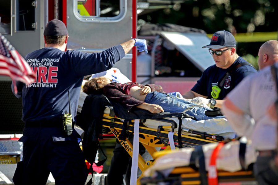 Medical personnel tend to a victim outside of Stoneman Douglas High School in Parkland, Fla., after a shooting on Wednesday, Feb. 14, 2018. (John McCall/Sun Sentinel/TNS)
