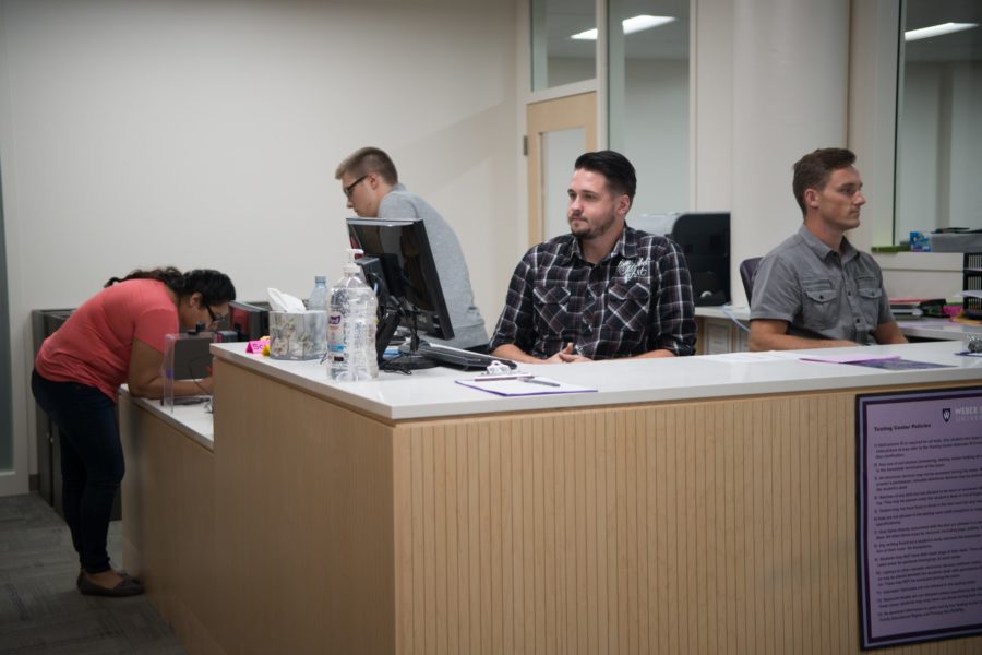 Remington Payton, left, and Nick Romney, right, work in the testing center, waiting to assign people computers. (Joshua Wineholt / The Signpost)