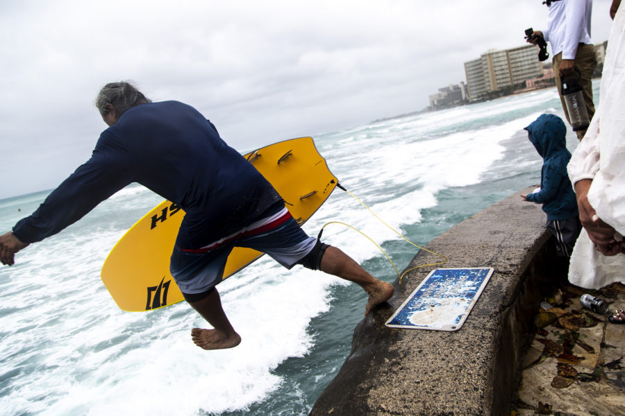 A man leaps off the wall into sotrm surge surf, as Oahu braces for the arrival of Hurricane Lane along Waikiki Beach on Aug. 24 in Honolulu, Hawaii. (Kent Nishimura/Los Angeles Times/TNS)