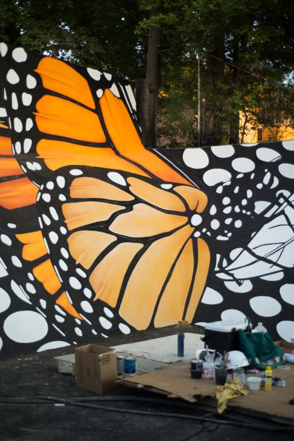 Materials used for the mural set out in front of the painting of a monarch butterfly. (Joshua Wineholt / The Signpost)