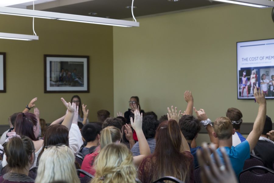 First time attendees at the meeting raise their hands. (Kelly Watkins / The Signpost)