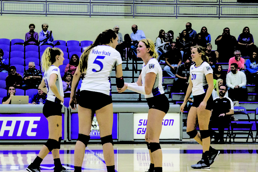 #1 Rylin Roberts shaking hands with teammate #5 Andrea Hale before they play their match against SUU. (Sara Parker / The Signpost)