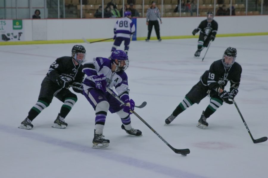 Ken Gorges (4) looks for teammates to pass the puck to while surrounded by Willistons players. (Sarah Catan / The Signpost)