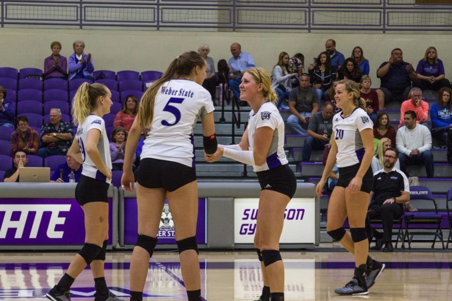 #1 Rylin Roberts shaking hands with teammate #5 Andrea Hale before they play their match against SUU. (Sara Parker / The Signpost)