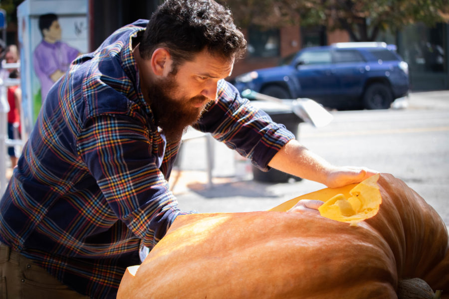 Adam Smith carving an oversized pumpkin at the Harvest Moon Celebration. (Kalie Pead/ The Signpost)