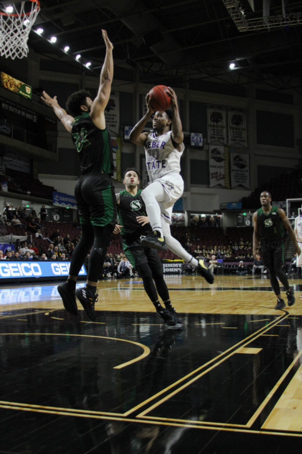 Jerrick Harding, WSU senior, jumping for the layup against Esposito. (BriElle Harker / The Signpost)